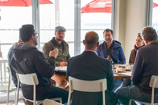 A group in discussion around a table.