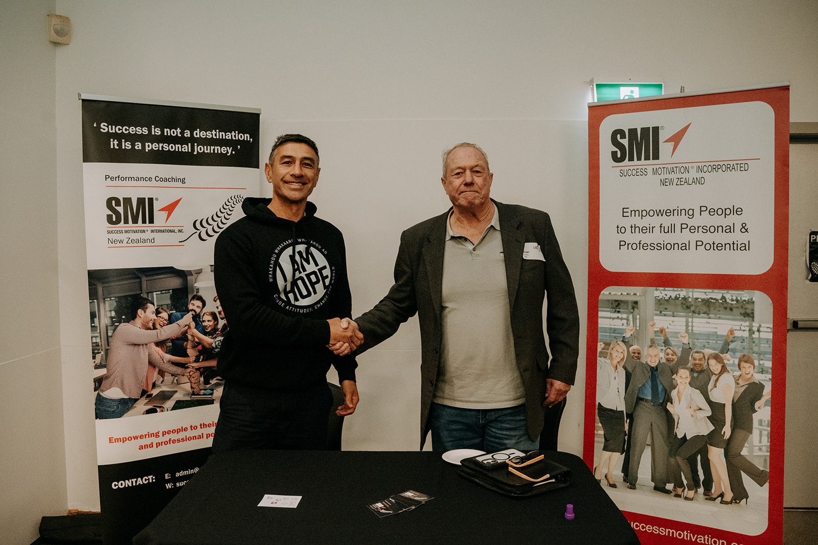 Roger Evans greeting an attendee at an SMI New Zealand event.